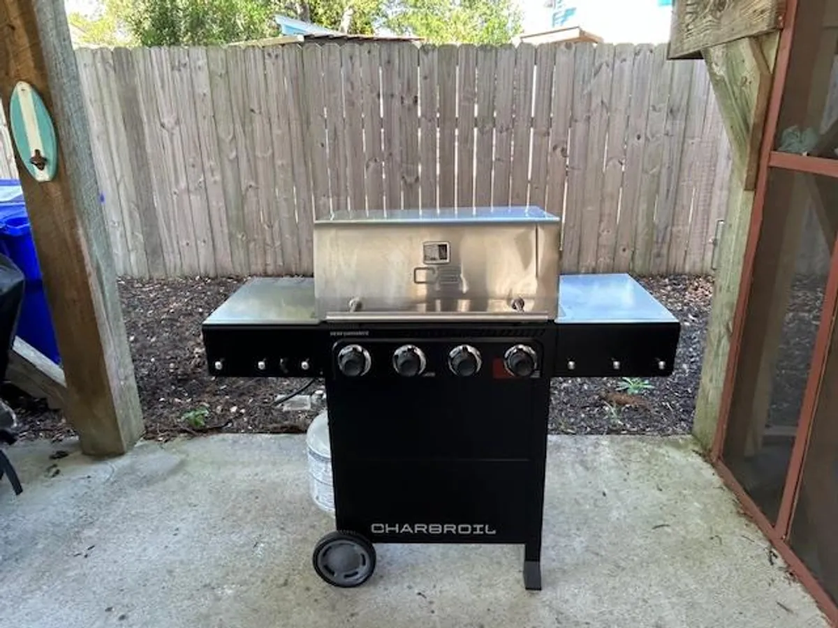 A focused view of the backyard grill area, highlighting the grill set against the backyard fence. The setup is ideal for barbecuing and socializing, inviting guests to gather around for food and conversation.