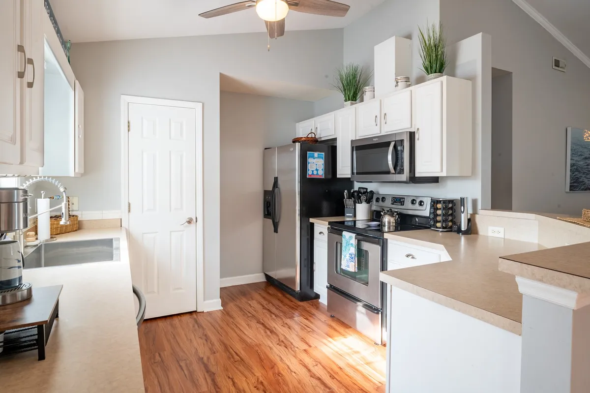 A modern kitchen with sleek appliances, generous countertop space, and a stylish light fixture, opening to the rest of the living area. The layout is perfect for cooking, entertaining, and group meals.